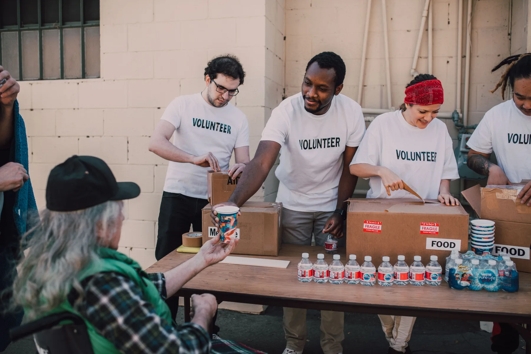 A diverse volunteer team distributing food and supplies at a community event
